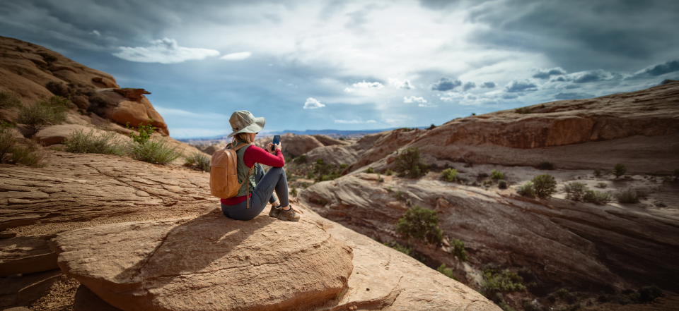 Woman on a mountain looking at a phone