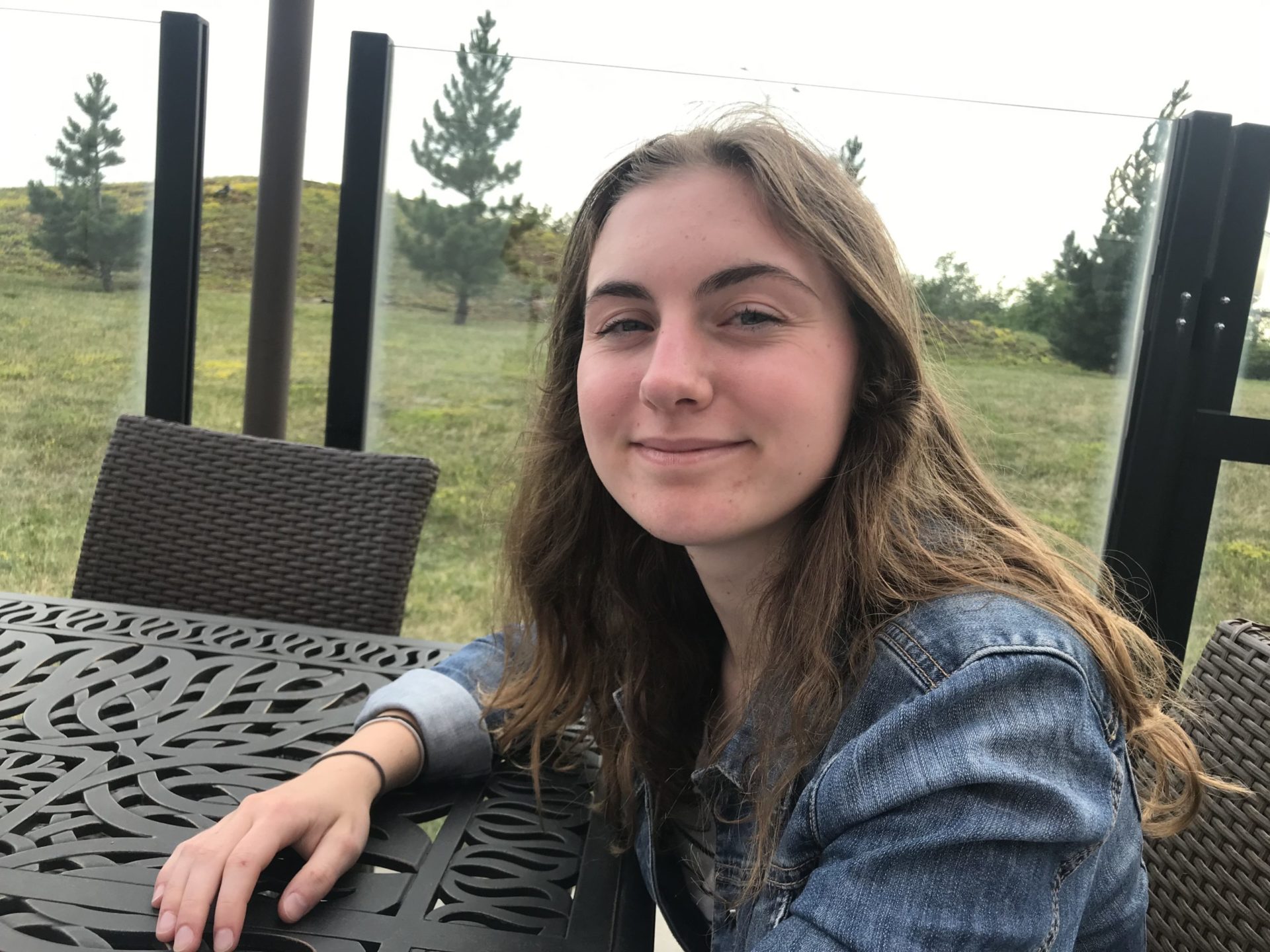 Ted Rogers Scholarship recipient Abby sitting at a table outside