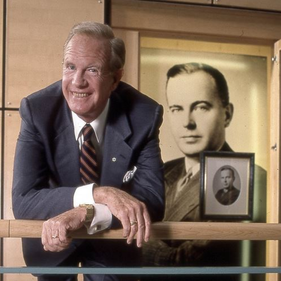 Ted Rogers posing with old photos and smiling