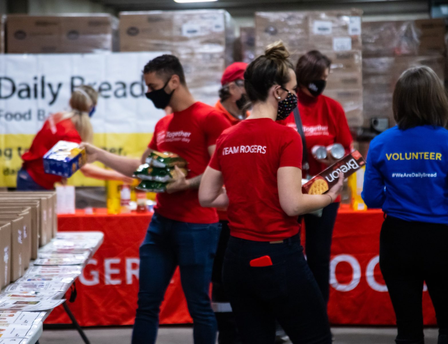 Group of Rogers volunteers packing boxes with food