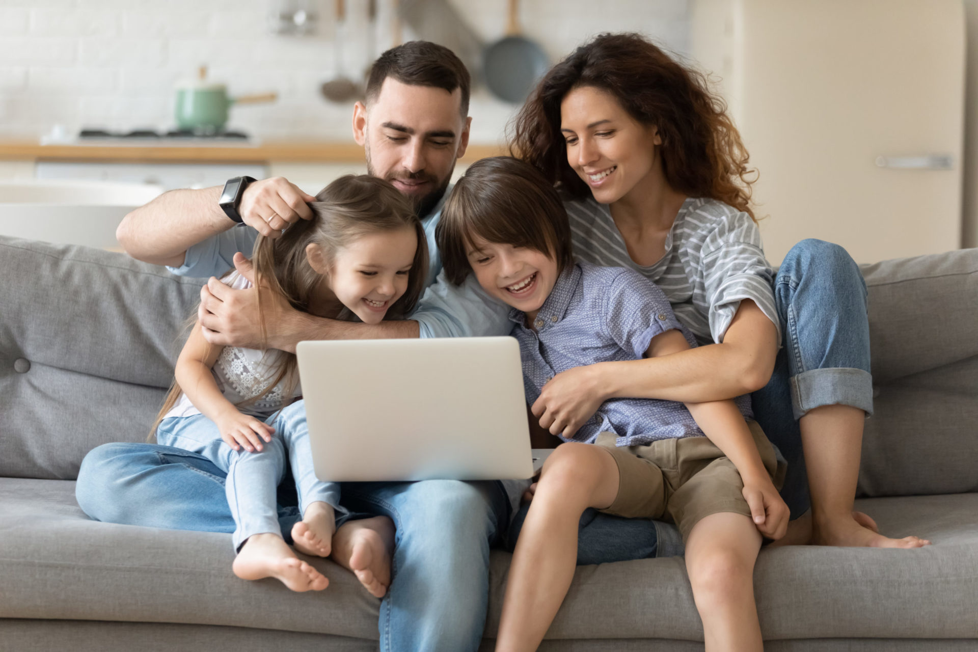 Happy family using a laptop on a sofa