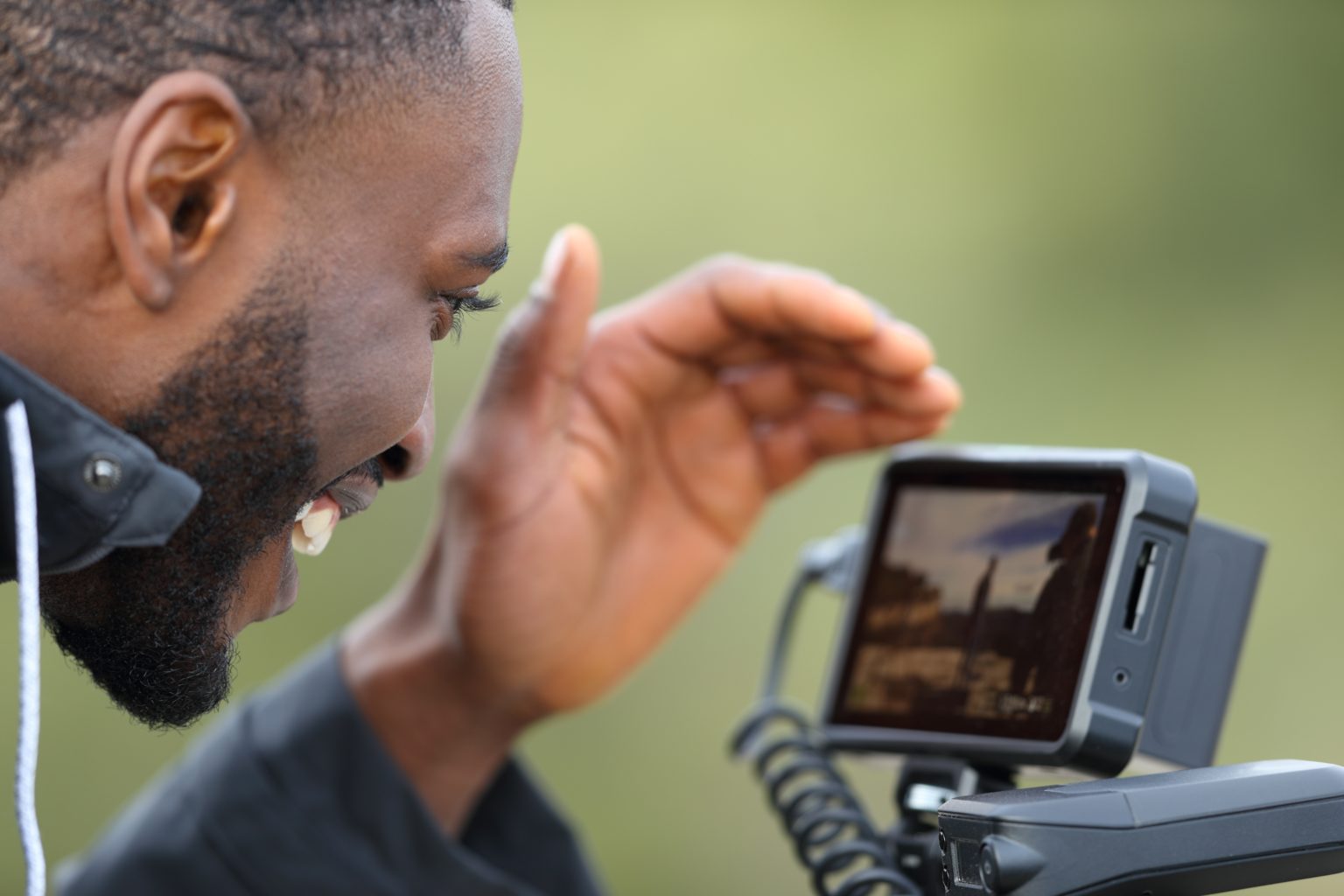 Close up of videographer recording video on camera outside